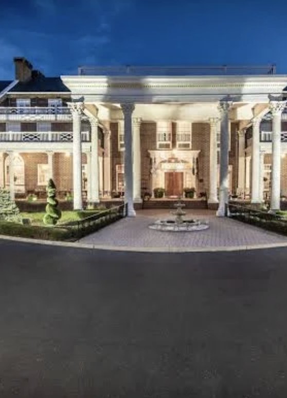 The white-columned portico and fountain court of The Mimslyn Inn at dusk